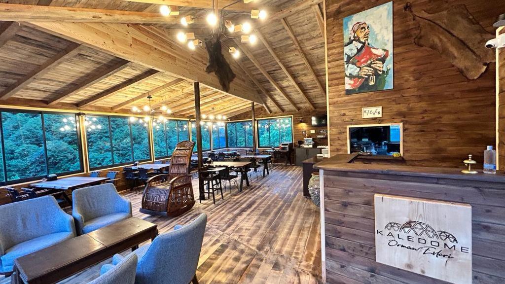 贾马里海姆森Kaledome Orman evleri的餐厅拥有木墙和桌椅