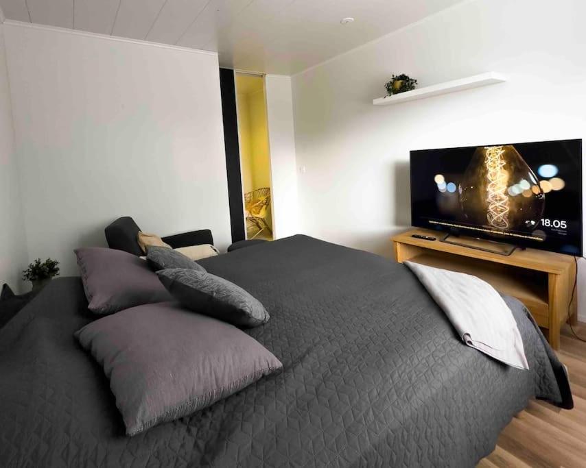拉彭兰塔Moderni huoneisto loistavalla paikalla - 65’Smart TV, nopea netti的一间卧室配有一张床和一台平面电视