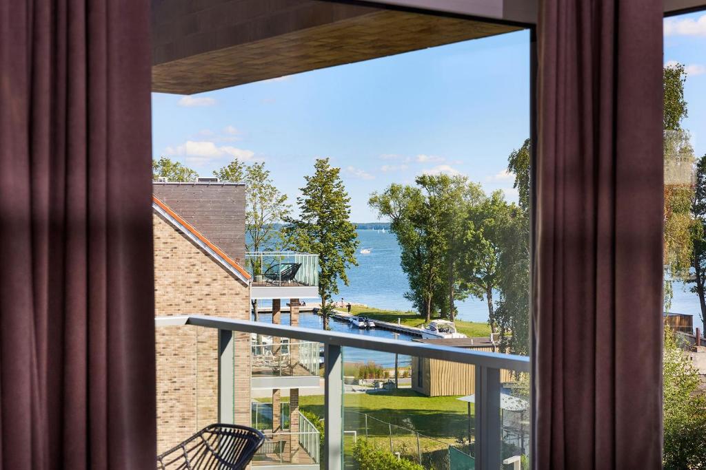 吉日茨科Apartament E18 w Nautica Resort nad jeziorem w Giżycku的客房设有一个享有水景的阳台。
