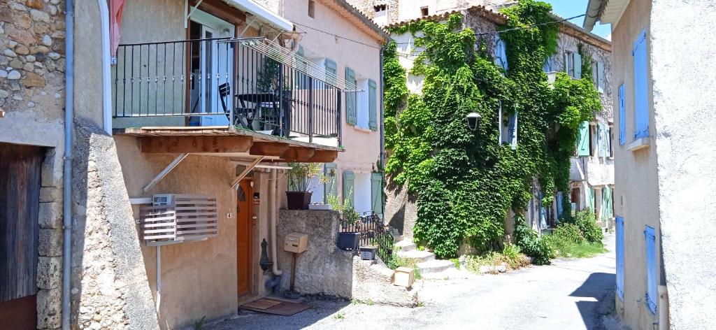PuimoissonMaison de village en Provence的一条拥有建筑、阳台和藤蔓的小巷