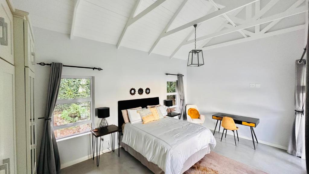 德班Stylish Loft Style Apartment的白色卧室配有床和书桌