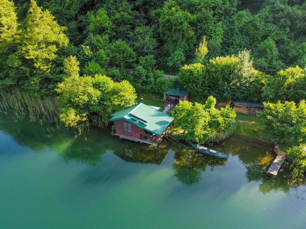 亚伊采ECO cabin Plivsko jezero Jajce的水面上岛上房屋的空中景观