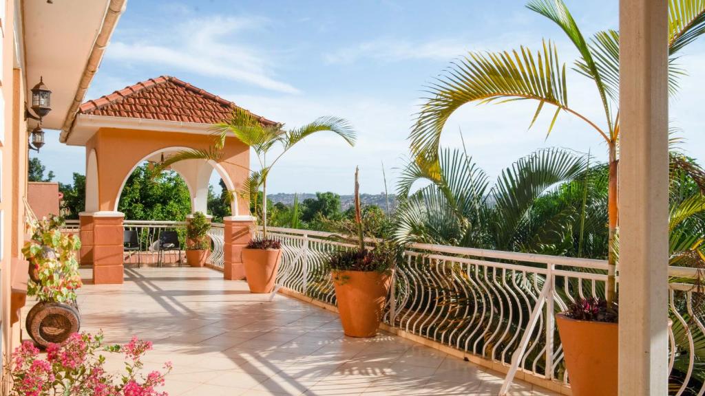 坎帕拉The Terrace Villa的阳台种有盆栽植物和白色围栏
