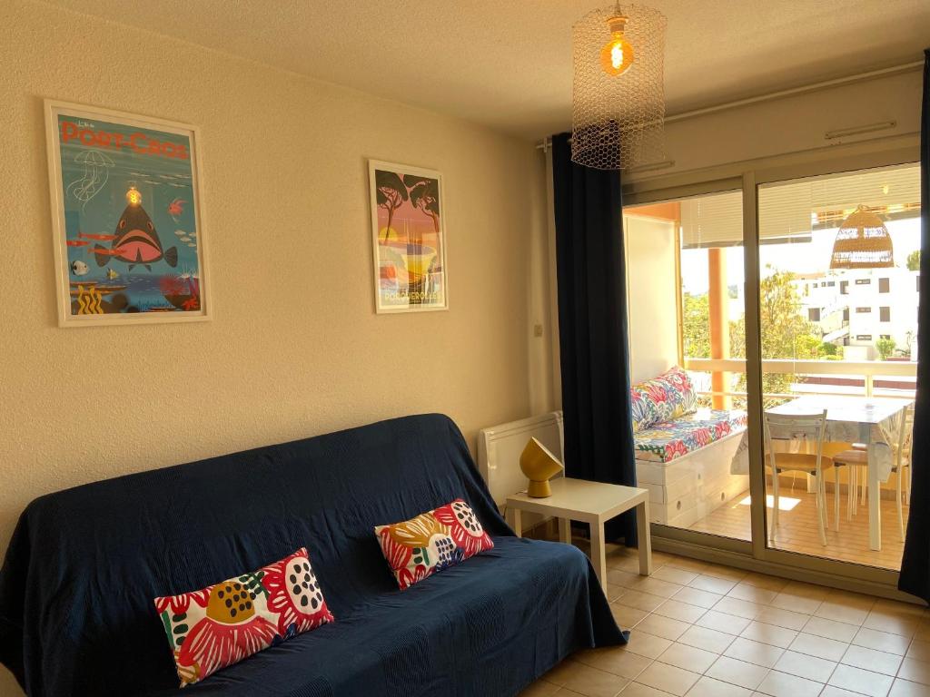 博尔马斯·莱斯·米默萨斯Appartement La Favière的一间带蓝色沙发的客厅和一个阳台