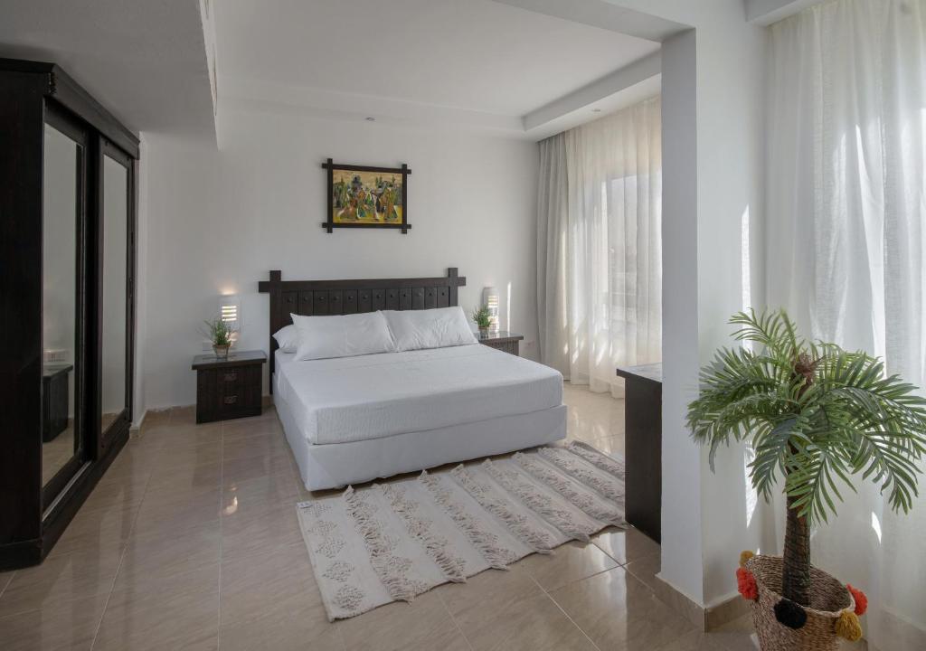 马特鲁港Olives at Santa Monica的卧室配有白色的床和盆栽植物