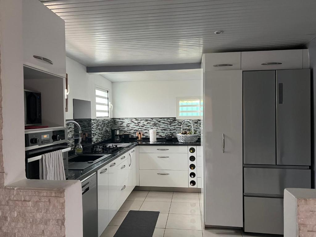 皮特尔角城Charmante Villa, kaz’ AA.Liyah的厨房配有白色橱柜和白色冰箱。