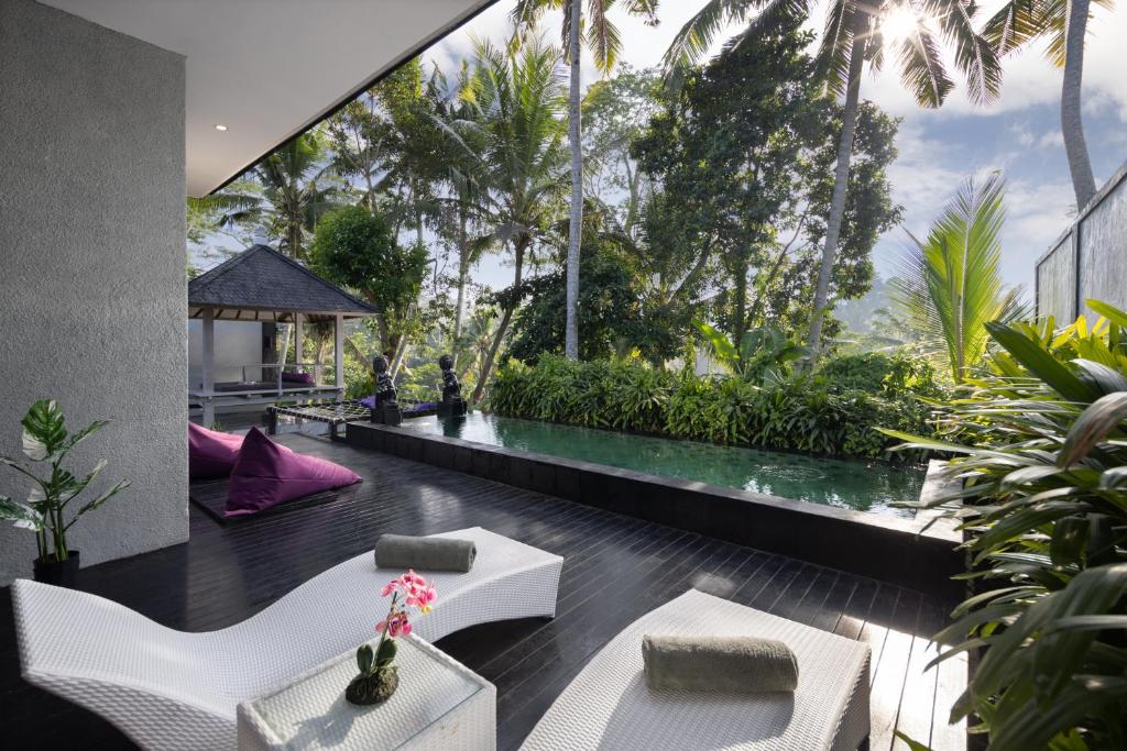 BedahuluCapung Asri Eco Luxury Resort with Private Pool Villas的客房享有花园的景致,配有白色家具。