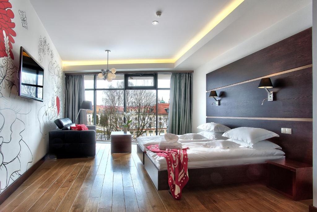 比亚韦斯托克雅集精品酒店的一间卧室设有一张大床和一个大窗户