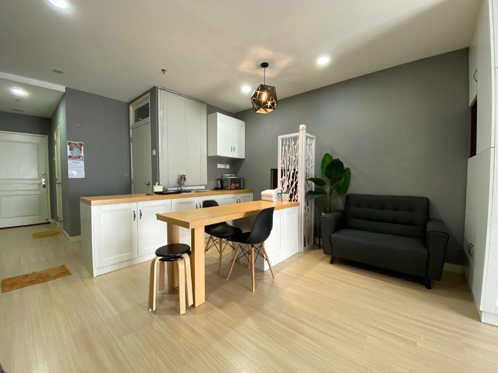 金宝A Modern & Homely Studio with Pool and Gym的厨房配有木桌和黑色沙发。