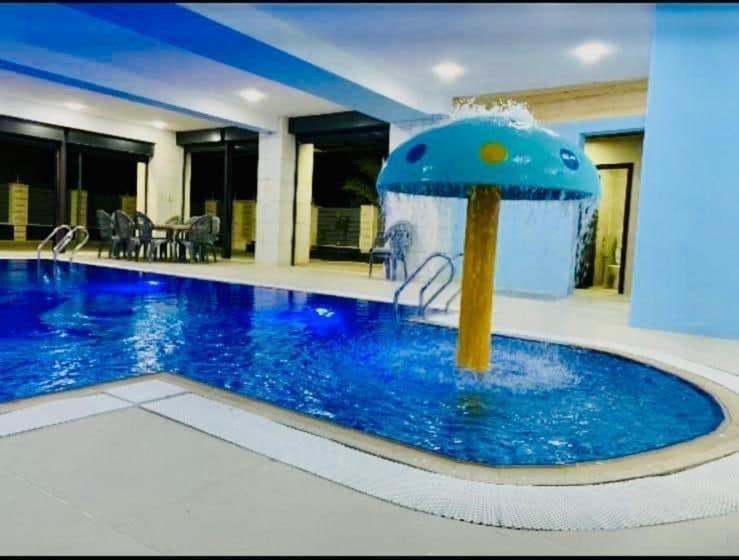 杰里科villa wardet algabal的一座建筑中间的游泳池,有一个喷泉