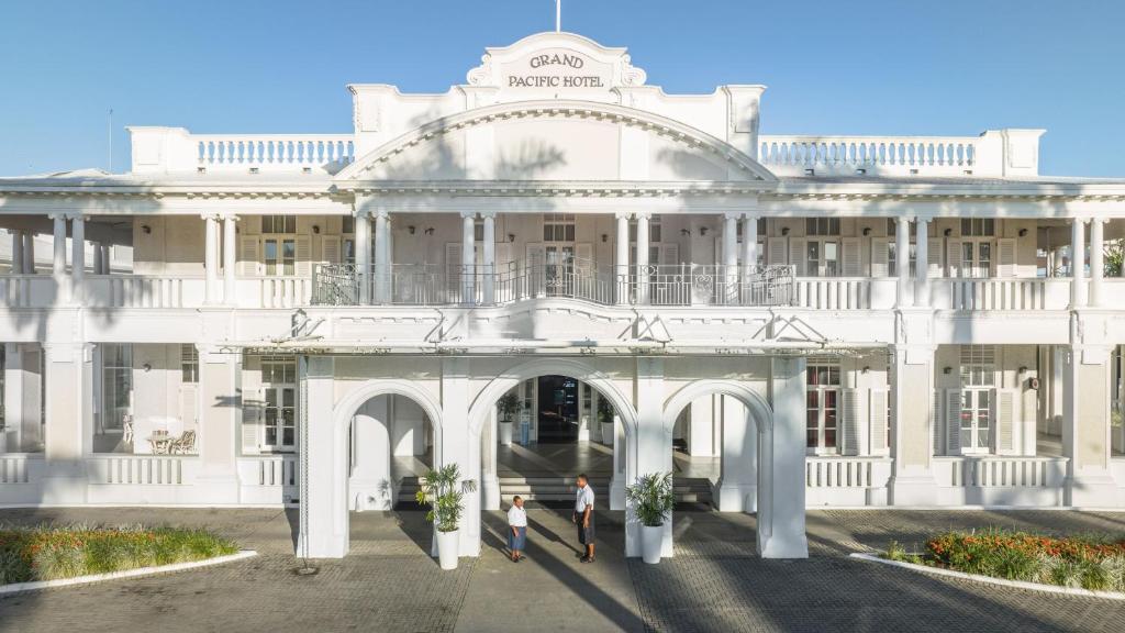 苏瓦太平洋大酒店的两个人站在白色建筑前