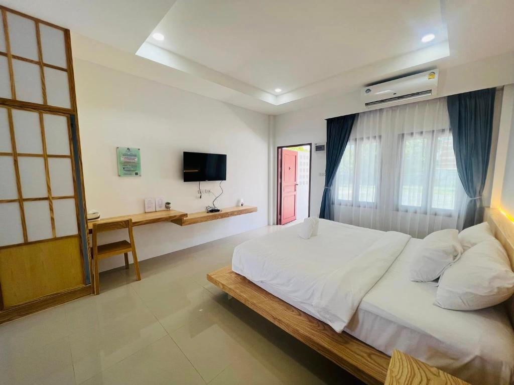 Ban Noen Makokสราญรัตน์รีสอร์ท的卧室配有一张白色大床和一张书桌