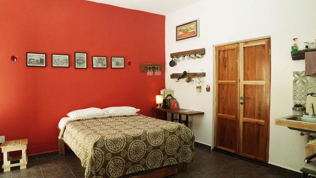 坎佩切Habitacion Roja / Casa del Café的红色的房间,配有床和水槽