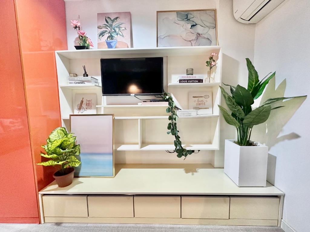 卡加盐德奥罗Smart Condominium in Cagayan de Oro City的一间在植物架子上配有电视的房间