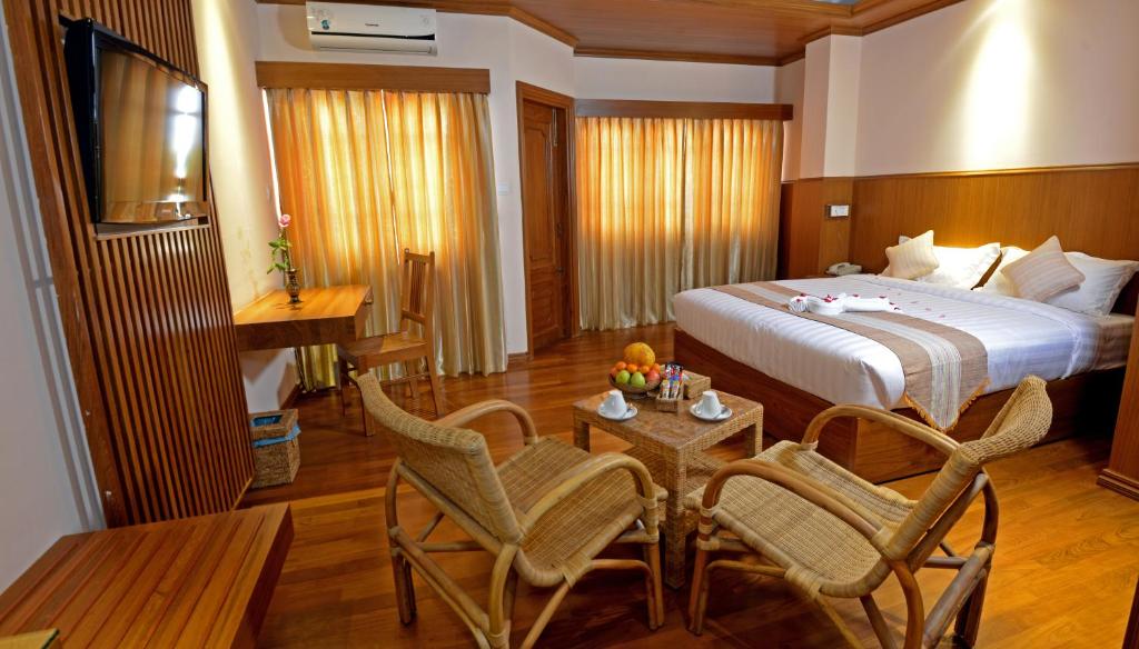 仰光悉尼酒店的酒店客房带一张床、一张桌子和椅子