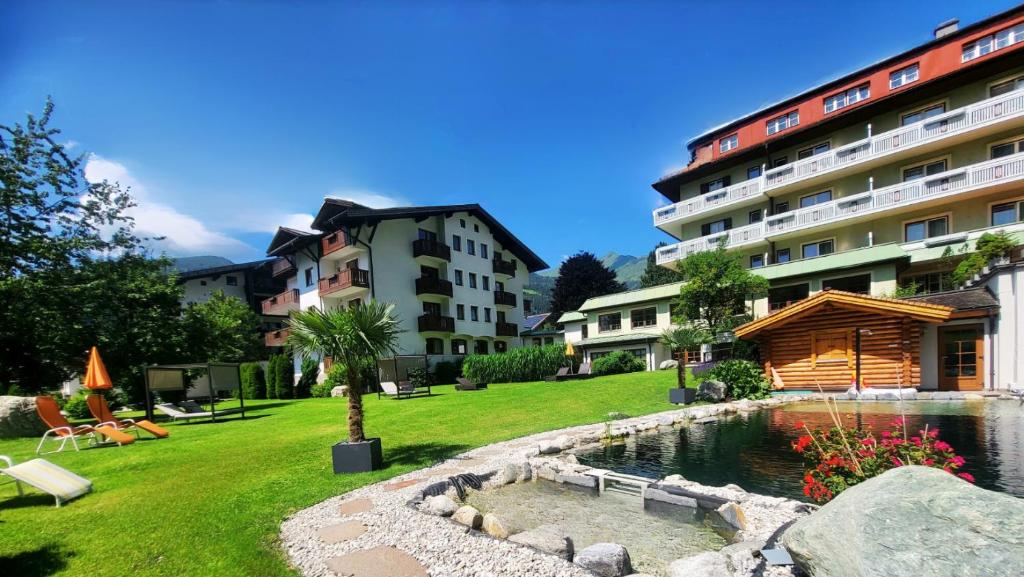 巴特霍夫加施泰因劳舍尔帕拉塞尔苏斯酒店的一个带池塘和建筑的酒店庭院