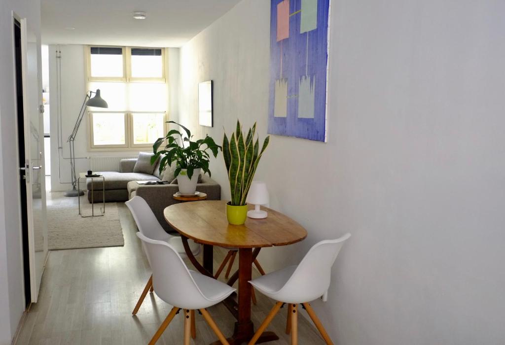 阿姆斯特丹Ground Floor Apartment Westerpark的客厅配有桌子和白色椅子