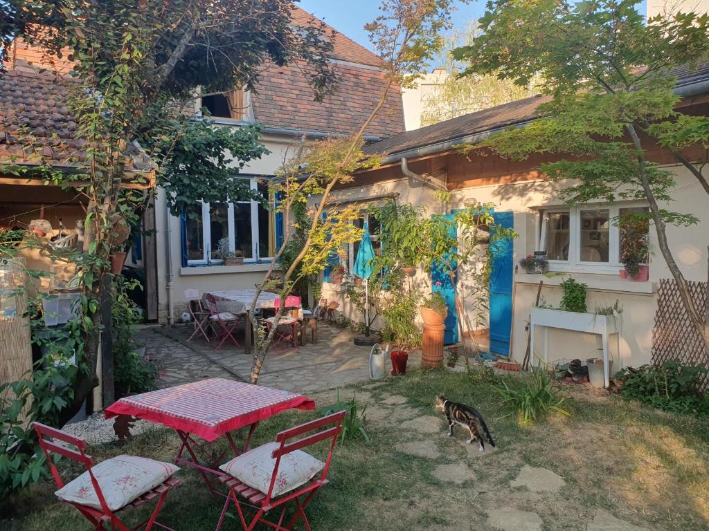 第戎Le Clos du Moulin Dijon, avec son jardin calme et romantique, la campagne à la ville的房屋前设有带桌椅的天井。