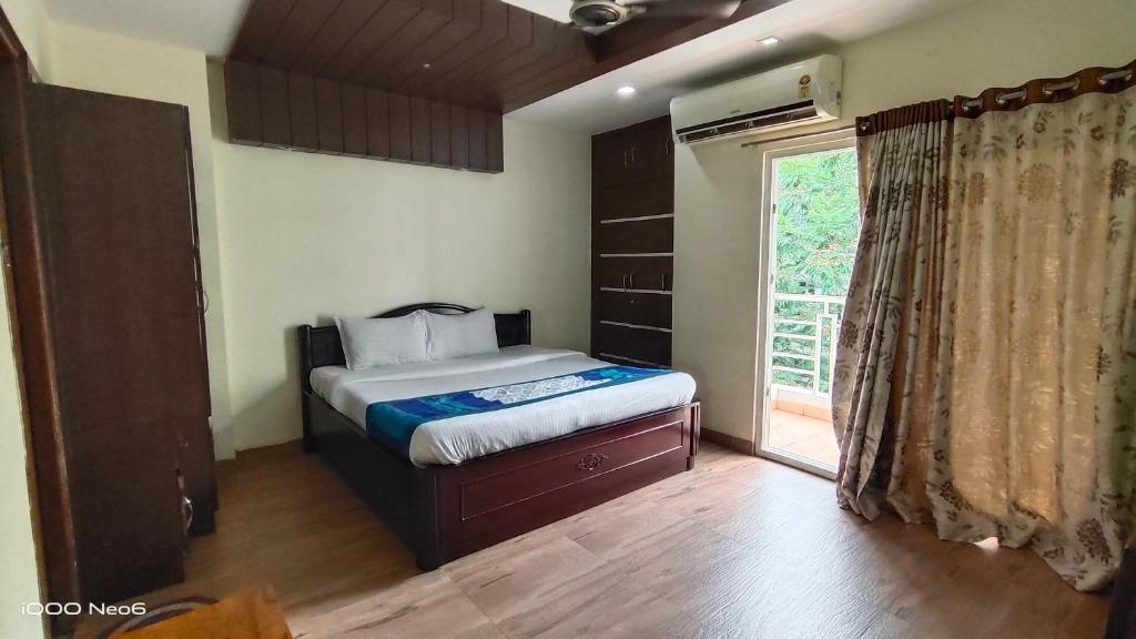 海得拉巴Hitech Shilparamam Guest House的一间卧室设有一张床和一个大窗户
