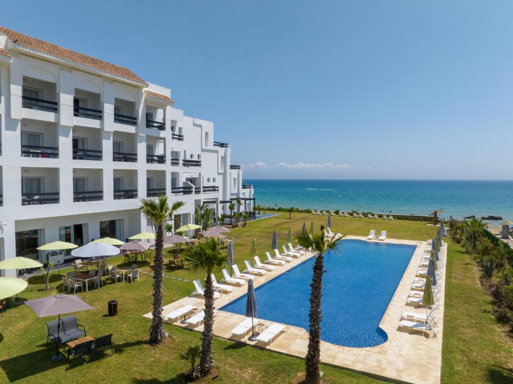 玛丽娜斯米尔PLAYA DEL PACHA Suites Hotel的享有酒店游泳池和大海的景色