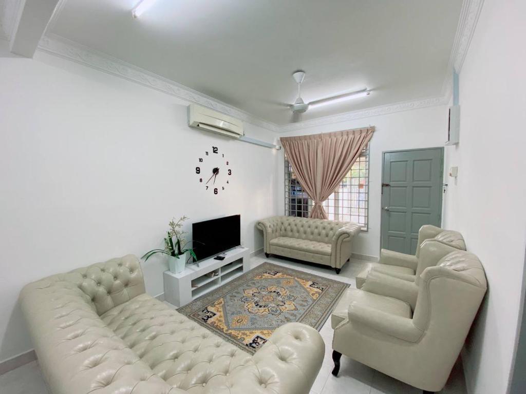 瓜拉丁加奴Homestay Murah Kuala Terengganu的客厅配有沙发、椅子和电视