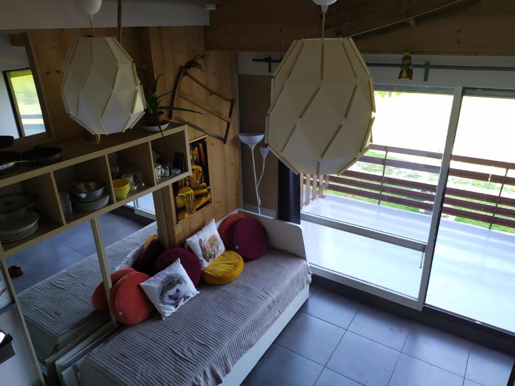 莱鲁斯Studio cosy ambiance châlet的客房设有带枕头的沙发和窗户。