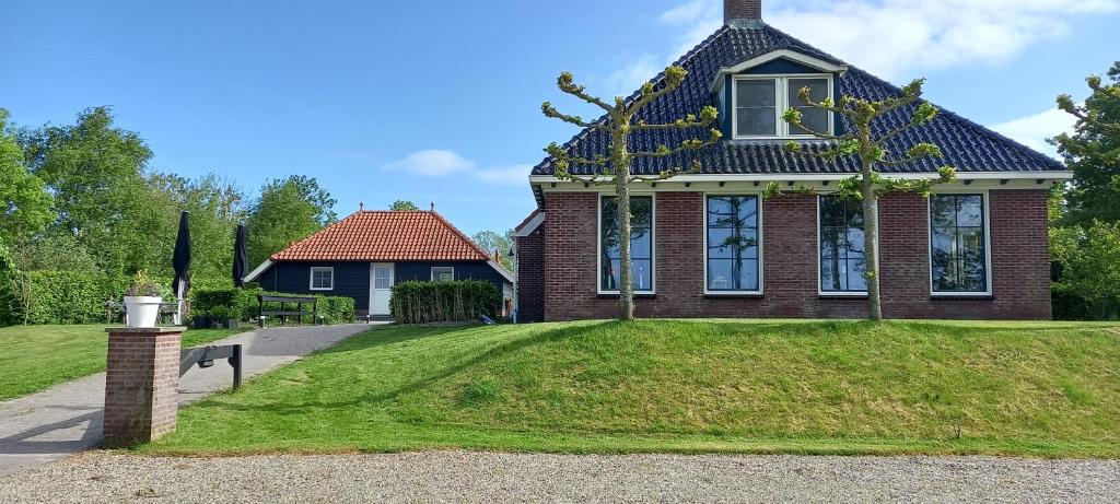 MolkwerumB&B Stations Koffiehuis的前面有绿色草坪的房子