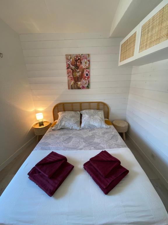 圣马迪拉莫Appartement Duplex Climatisé Le Trident的一间卧室配有一张带紫色毛巾的床