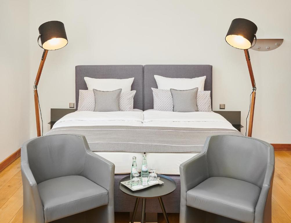 杜塞尔多夫Hotel Mutterhaus Düsseldorf的一间卧室配有一张大床和两把椅子