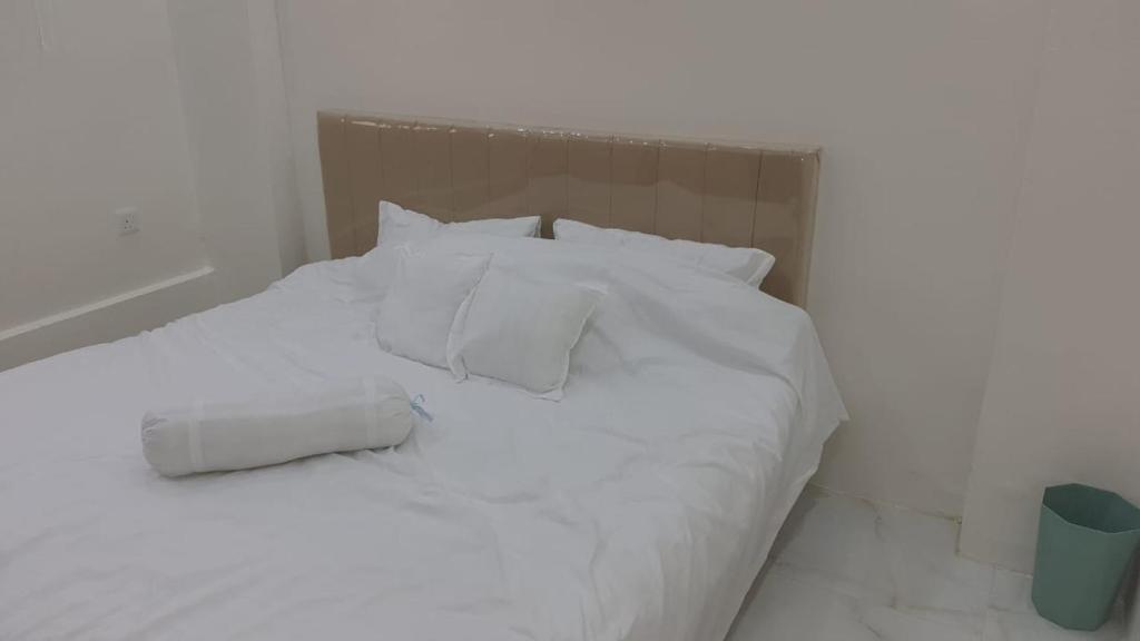 Al ‘Awālīابو عامر للشقق المفروشه的白色的床、白色床单和枕头