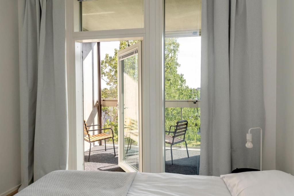 奥卢Kotimaailma Apartments Loimu V的一间卧室设有一张床和一个滑动玻璃门
