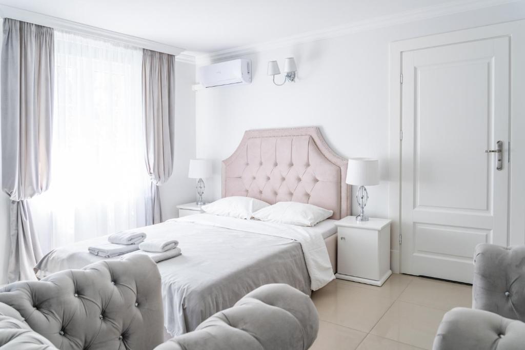 库瑞尼卡慕斯卡弗雷德里克别墅的白色卧室配有一张大床和两把椅子