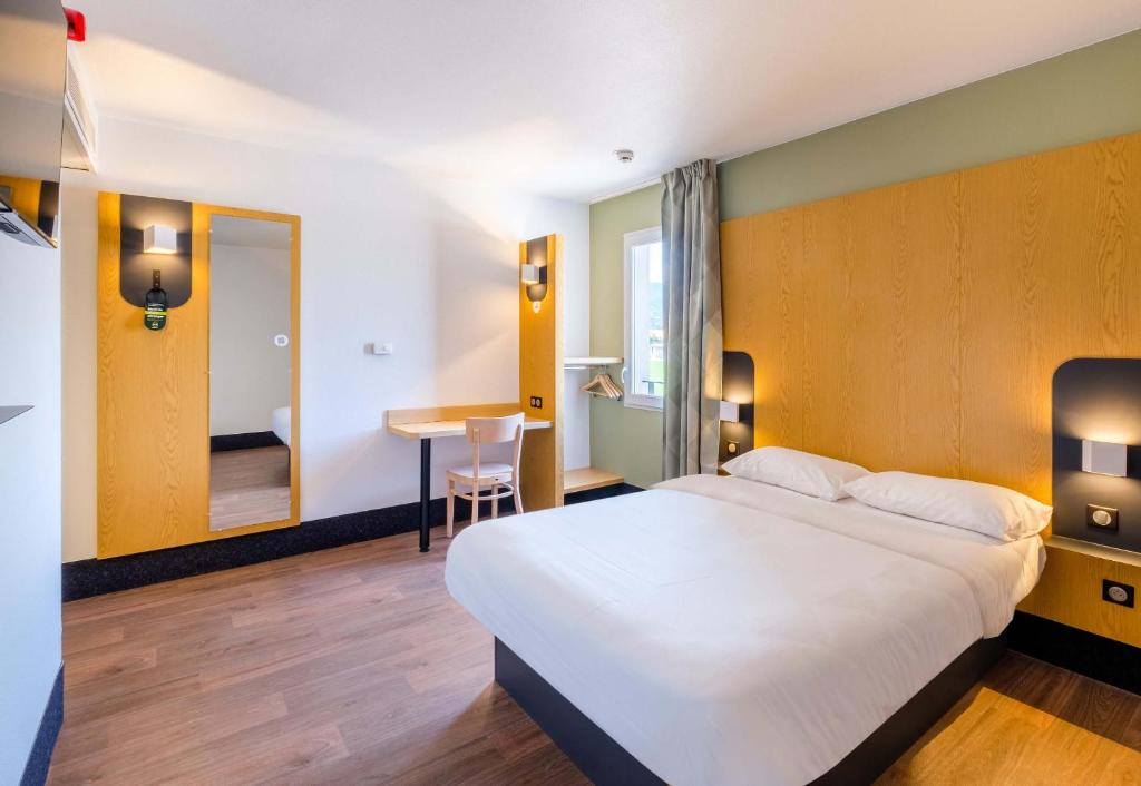 戛纳B&B HOTEL Cannes La Bocca Plage的酒店客房设有一张大床和一张书桌。