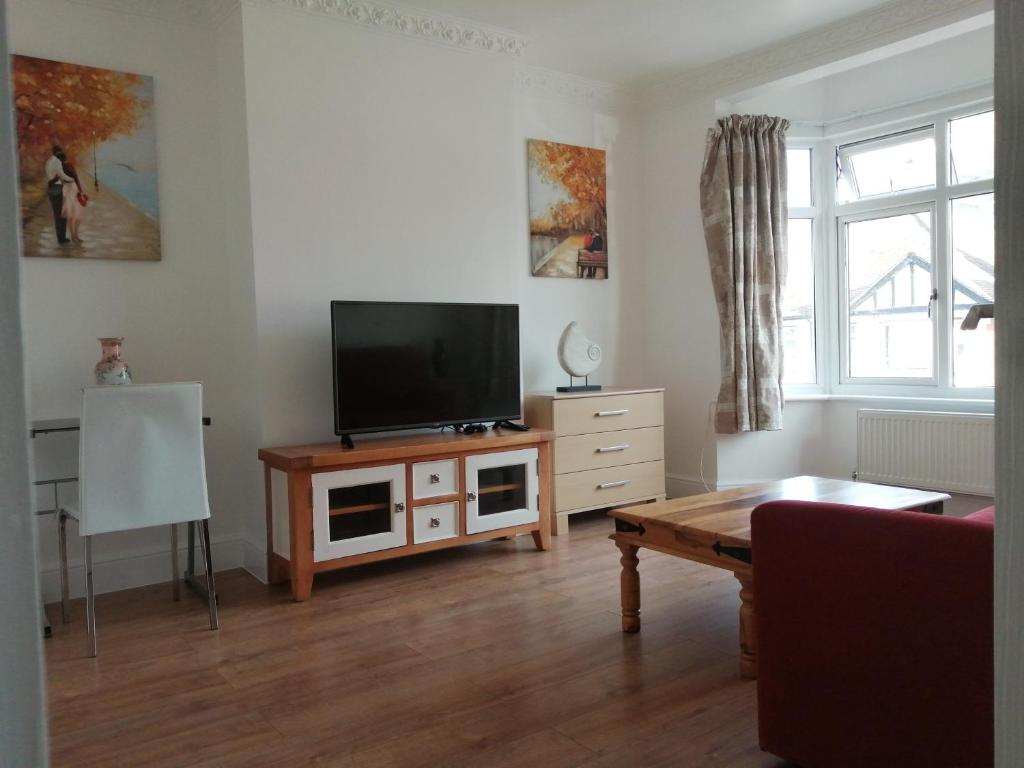 罗姆福特Lovely 3 Bedrooms Flat Near Romford Station With Free Parking的客厅配有木桌上的平面电视