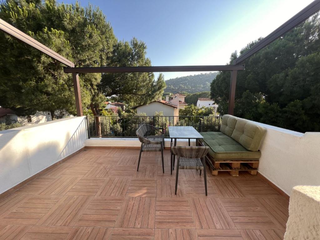 伊兹密尔Chic Villa with Terrace and Rooftop in Izmir的阳台的天井配有桌椅