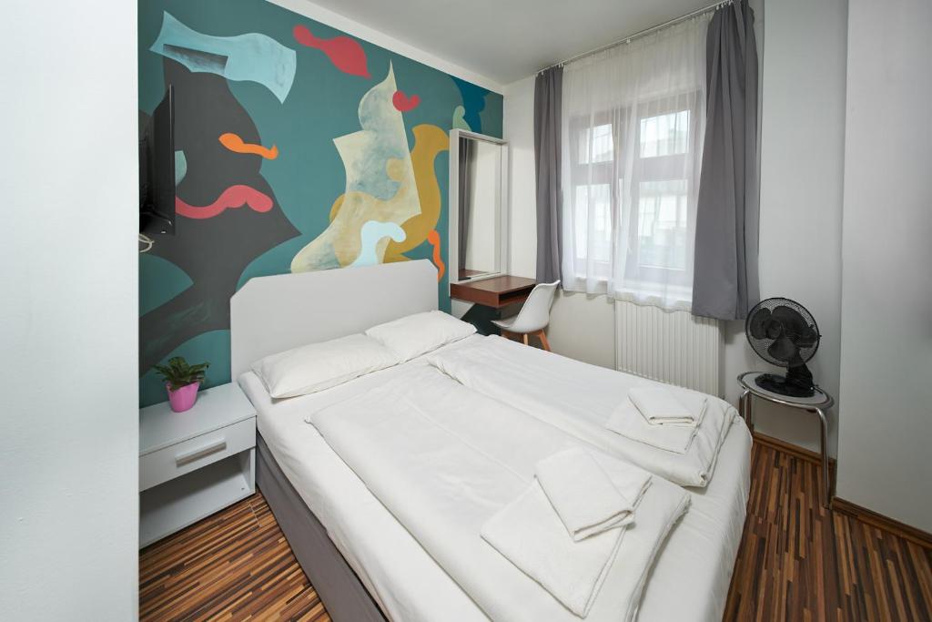 弗罗茨瓦夫阿奇拉住宿加早餐酒店的卧室配有白色的床和色彩缤纷的墙壁