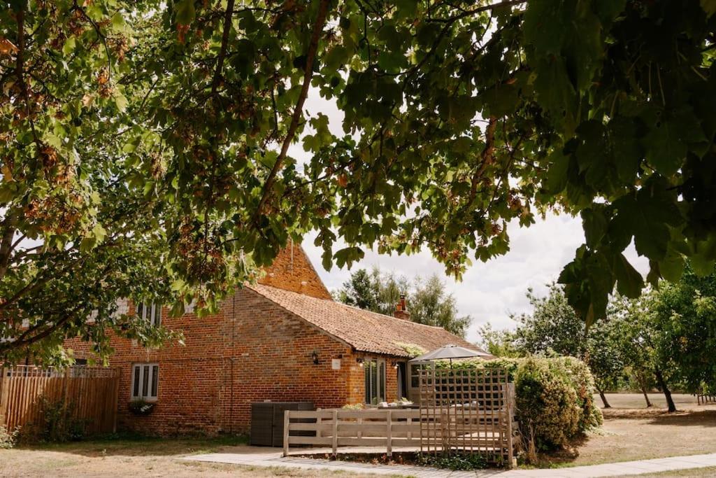 PentneyThe Threshing Barn - relaxing countryside spa break的前面有长凳的砖砌教堂