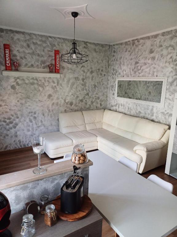 布雷西亚4 PASSI DAL CENTRO的客厅配有白色的沙发和桌子