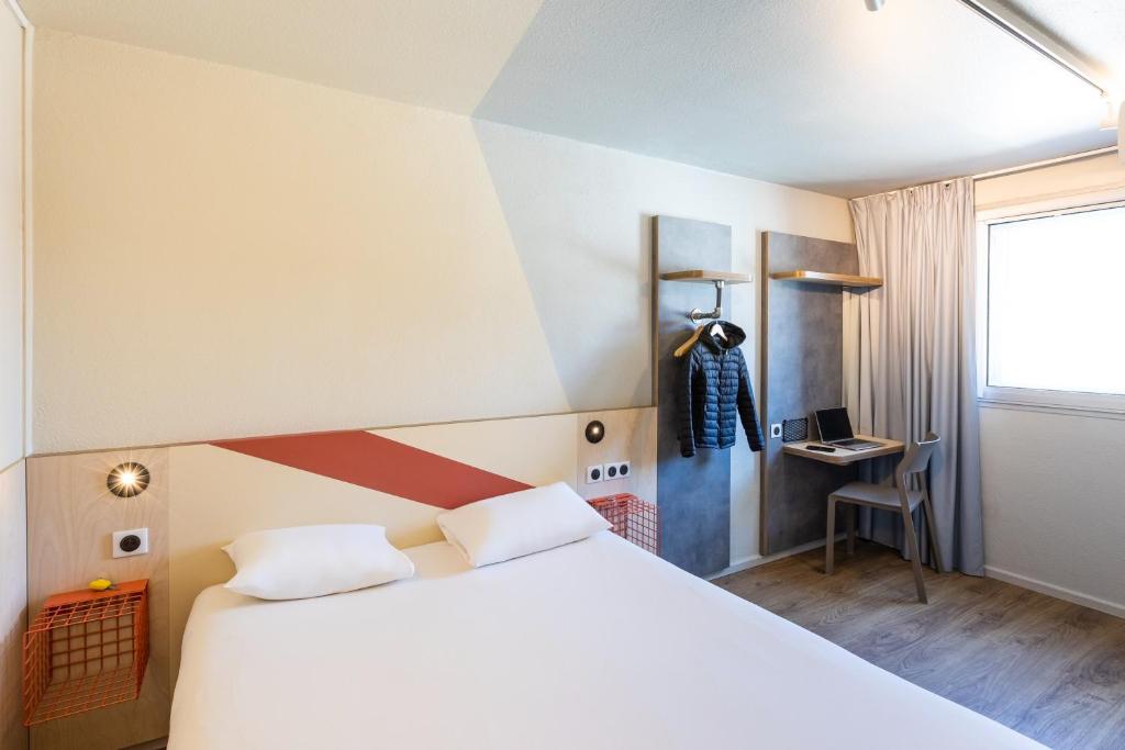 昂古莱姆昂古莱姆中心宜必思快捷酒店的卧室配有一张白色大床和一张书桌