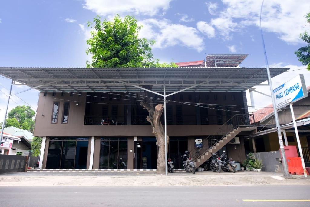 LutanHotel Puri Lembang near Universitas Sulawesi Barat Majene的前面有棵树的建筑