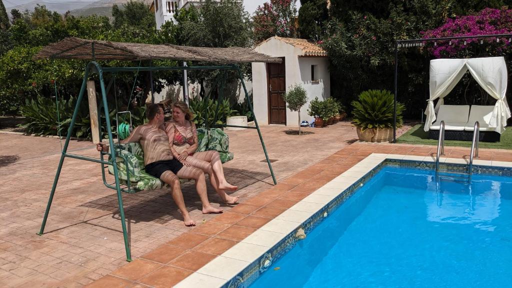 TalaraLa Cañota 2-Floors King Rooms Adults Only的两个女人坐在游泳池旁的椅子上