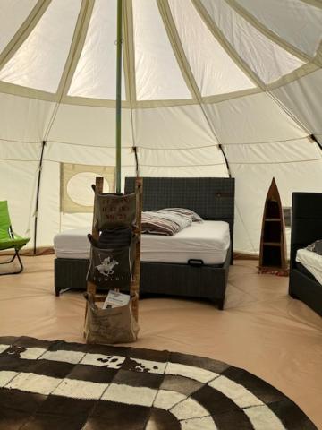 NeerpeltNatuur-like Glamping in Bosland的带帐篷的房间,配有一张床和地毯