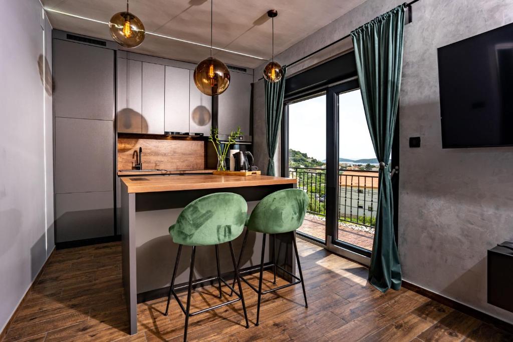 拉布Modern studio with a beautiful view的厨房配有柜台和2张绿色凳子