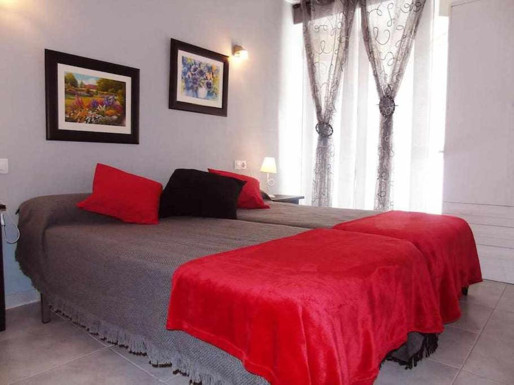 托雷德尔马尔A&N Plaza Sol的一间卧室配有一张带红色毯子的大床