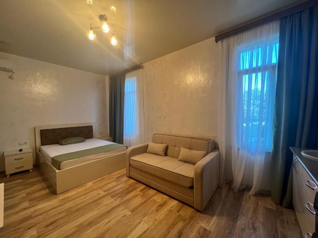 巴统Apartments NITA的一间卧室配有一张床、一张沙发和一个窗口