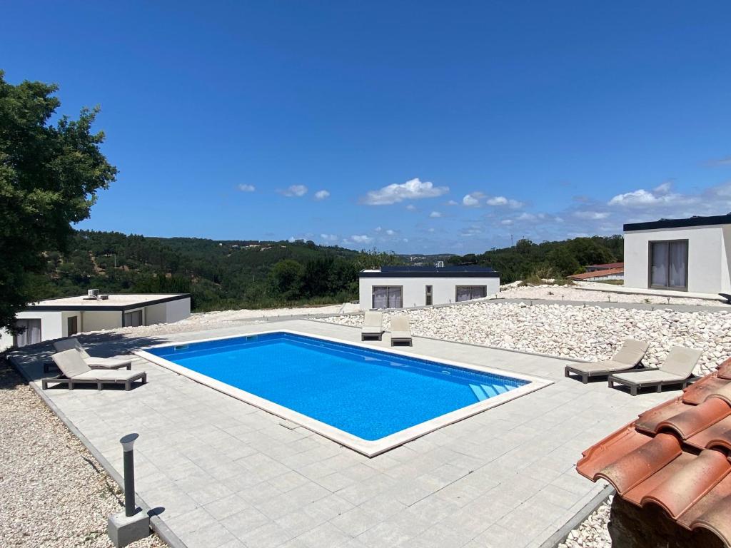 阿尔科巴萨Quinta Estrela d'Alva的一个带椅子的游泳池以及一座房子