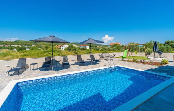 比比涅Villa Strkalj Bibinje的一个带椅子和遮阳伞的大型游泳池