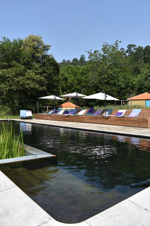 蓬蒂-达巴尔卡Drop-Inn Nature, Relax, Hike and SKATE的一个带椅子和遮阳伞的水池