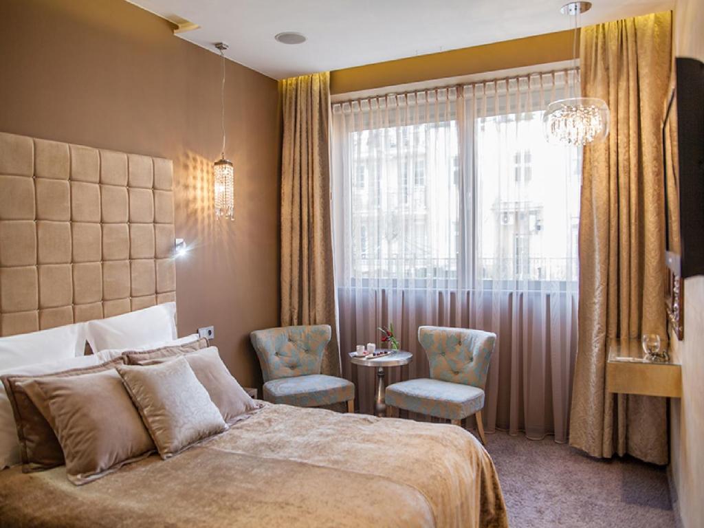 索波特Soleil Boutique H的一间卧室配有一张床、一张桌子和一个窗户。
