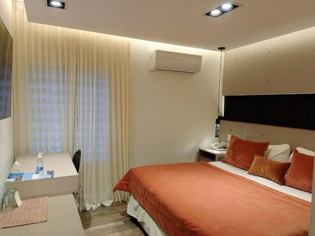 岑特纳里奥全球酒店 的配有一张床和一张书桌的酒店客房